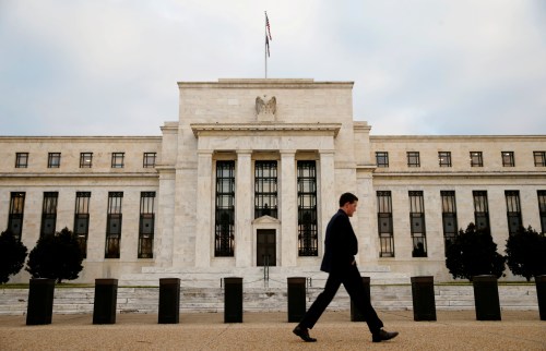 A man walks past the Federal Reserve Bank.
