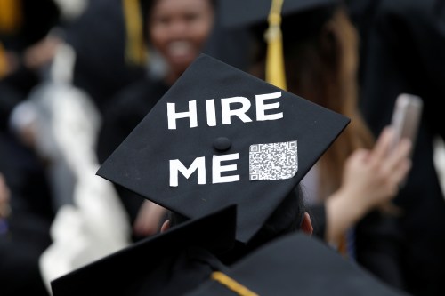 A graduating student of the City College of New York wears a message on his cap, saying "Hire me."