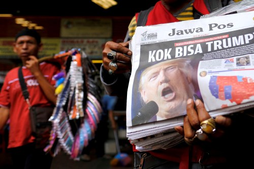 A newspaper seller holds a newspaper with an article about the election of U.S. Republican candidate Donald Trump as president, in Jakarta, Indonesia, November 10, 2016. The headline reads "Why Trump?"REUTERS/Beawiharta - RTX2SXWU