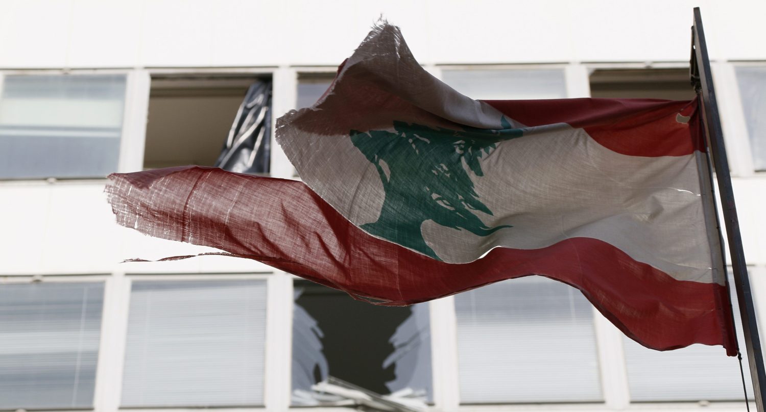 Lebanon's flag flies in front of damaged windows at the Starco building in front of the site of a bomb blast, which killed Lebanon's former Finance Minister Mohamad Chatah, in downtown Beirut December 28, 2013. Chatah, who opposed Syrian President Bashar al-Assad, was killed in a massive bomb blast on Friday which one of his political allies blamed on the Shi'ite Hezbollah militia. Former prime minister Saad al-Hariri accused Hezbollah of involvement in the killing of Chatah, his 62-year-old political adviser, saying it was "a new message of terrorism". REUTERS/Jamal Saidi (LEBANON - Tags: CIVIL UNREST POLITICS) - RTX16VMI