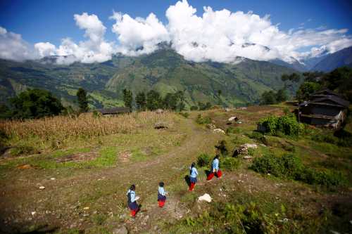Children walk to school in Kharay, Dolkha District, some 190 km (118 miles) northeast of Kathmandu September 15, 2013. Devi Budhathoki and three of her children, Manjura, Mandira, and Niraj all suffer from Congenital Hypertrichosis Lanuginosa, a very rare disease that causes excessive body hair growth, and which is sometimes referred to as "werewolf syndrome". They are undergoing laser hair removal in order to lessen their symptoms. Picture taken September 15, 2013. REUTERS/Navesh Chitrakar (NEPAL - Tags: HEALTH SOCIETY EDUCATION) ATTENTION EDITORS: PICTURE 07 OF 37 FOR PICTURE PACKAGE "LIVING WITH 'WEREWOLF SYNDROME'". TO FIND ALL IMAGES SEARCH 'BUDHATHOKI' - RTX1522K