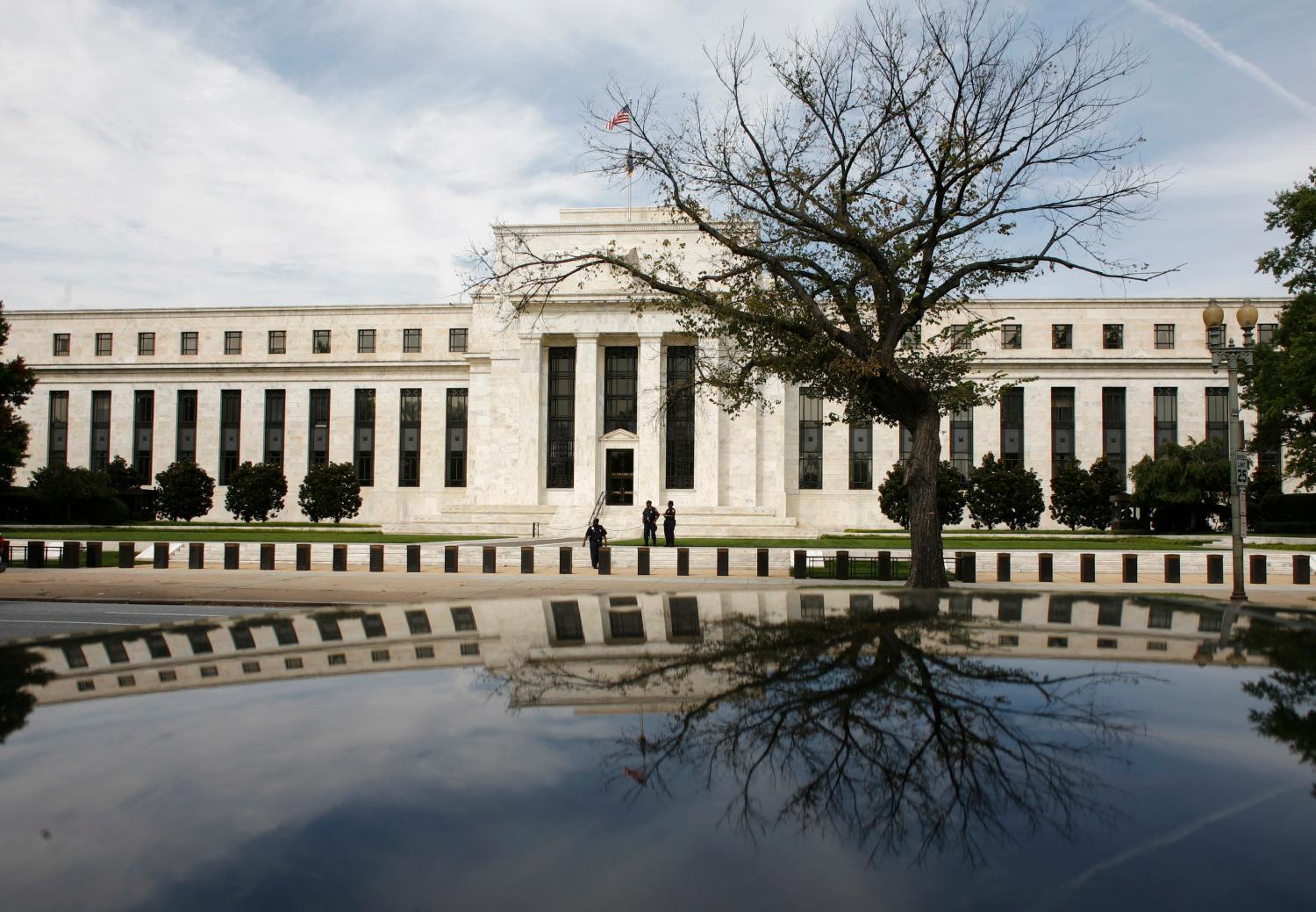 The Federal Reserve Building is reflected on a car in Washington