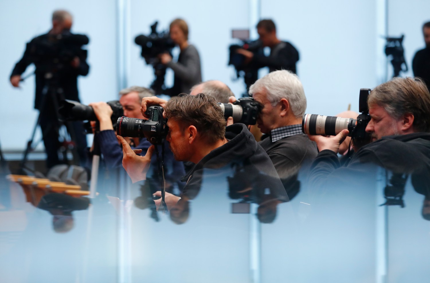Journalists take pictures during a news conference
