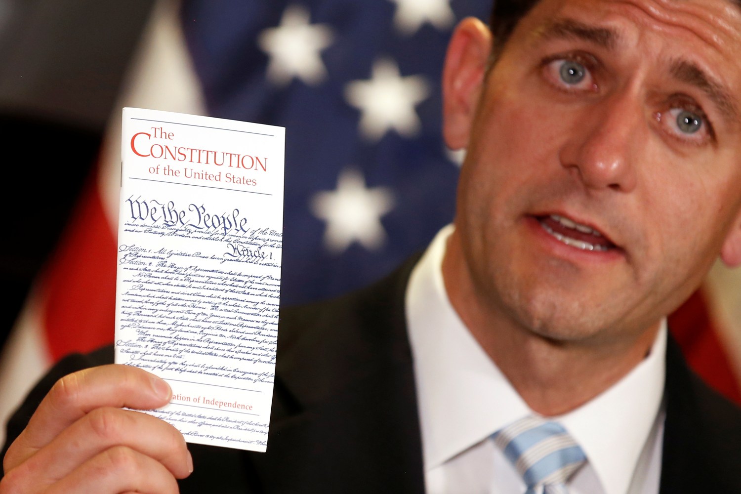 U.S. House Speaker Paul Ryan (R-WI) holds a copy of the United States constitution