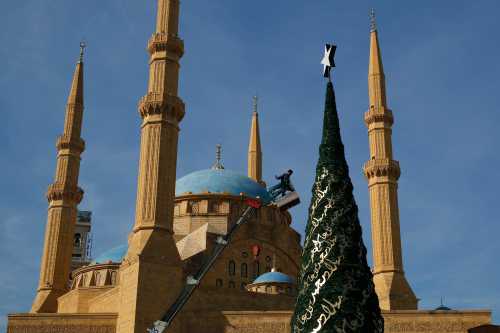A worker decorates a Christmas tree designed by Lebanese designer Elie Saab in front of the Al-Amin mosque in Beirut, Lebanon, December 9, 2015. Picture taken December 9, 2015. REUTERS/Jamal Saidi - RTX1Y14M