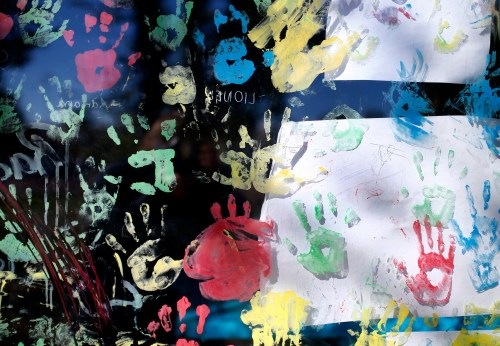 Colourful handprints decorate window of childcare facility