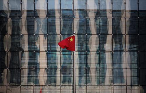 A Chinese national flag flutters at the headquarters of a commercial bank on a financial street near the headquarters of the People's Bank of China, China's central bank, in central Beijing November 24, 2014. REUTERS/Kim Kyung-Hoon/File Photo - RTSGATS