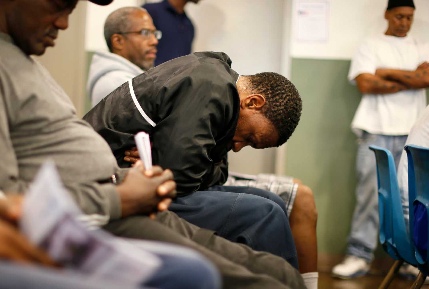 A black man lowers his head at a shelter on skid row in Los Angeles, California.