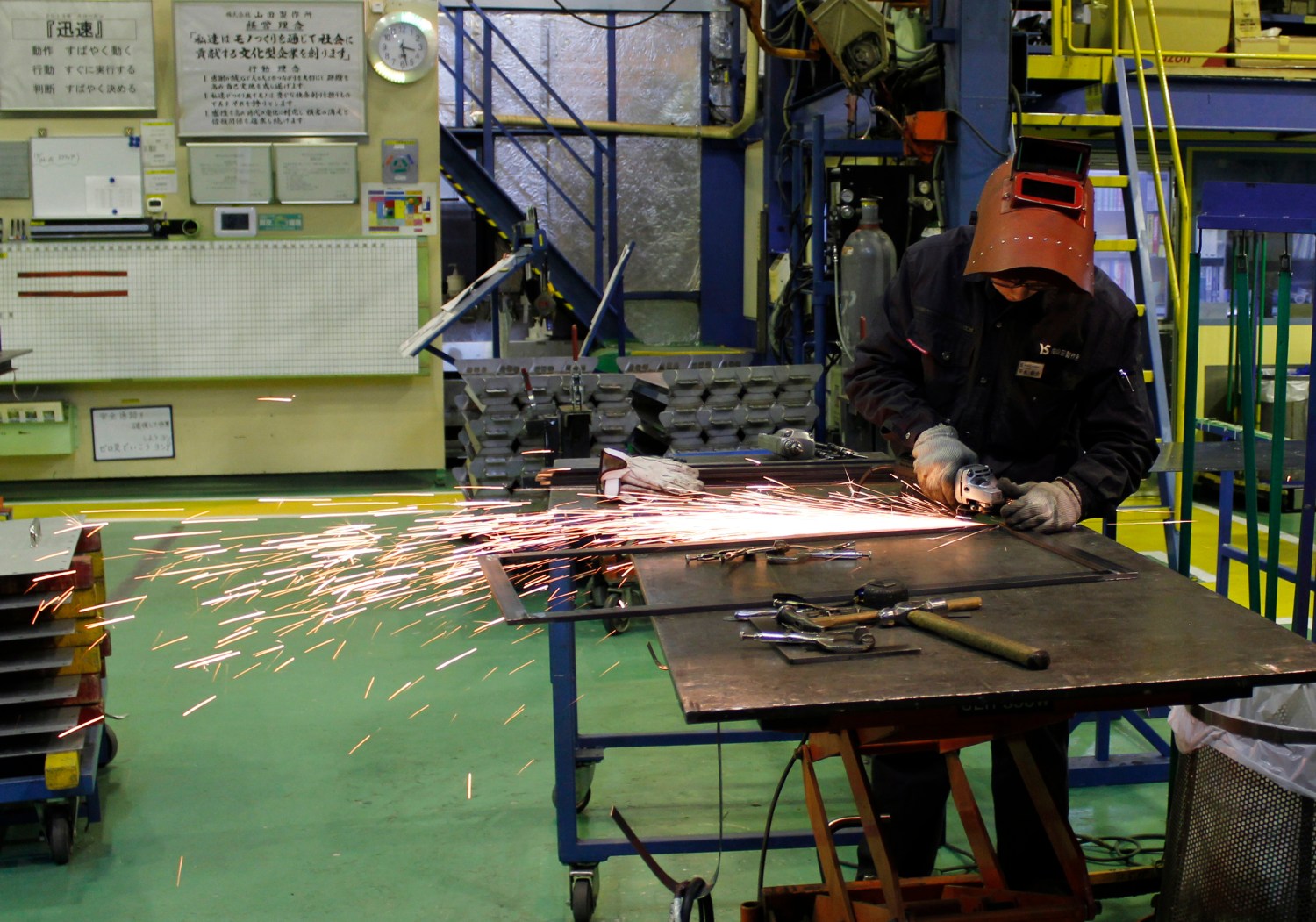 A worker cuts a metal at a sheet metal processing company.