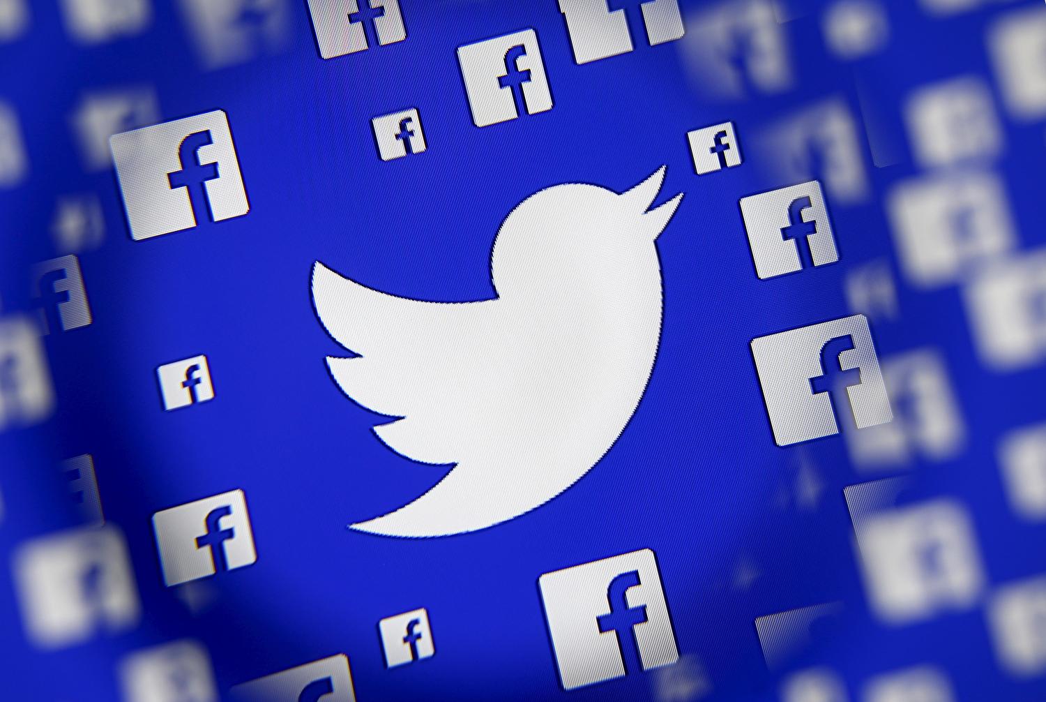 Logo of the Twitter and Facebook are seen through magnifier on display in this illustration taken in Sarajevo, Bosnia and Herzegovina, December 16, 2015. Broker's survey shows Twitter losing share to faster growing competitors such as Facebook's Instagram and Snapchat, despite co's multiple product and partnership launches this year, analysts write in note. REUTERS/Dado Ruvic - RTX1Z12A