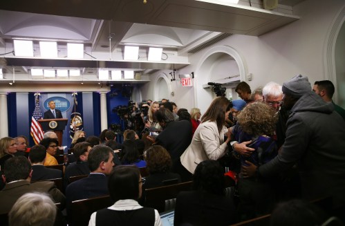 President Barack Obama (L) watches as journalists aid a colleague (2R) who collapsed in the White House press briefing room and help escort her to the doctor during Obama's last news conference of the year in Washington, U.S., December 16, 2016. REUTERS/Carlos Barria - RTX2VE63