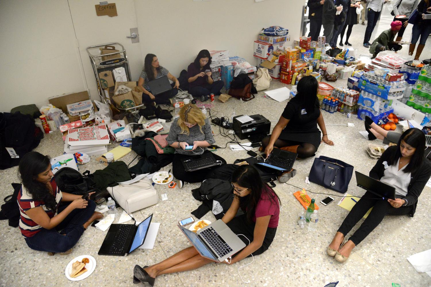 Lawyers and legal assistants network and use social media in the baggage claim area, amid supplies of pizza, water and other food, at Dulles International Airport, aiding passengers who have arrived and encounter problems because of Donald Trump's travel ban to the United States, in Chantilly, Virginia, in suburban Washington, U.S., January 29, 2017. REUTERS/Mike Theiler - RTSXZ6R