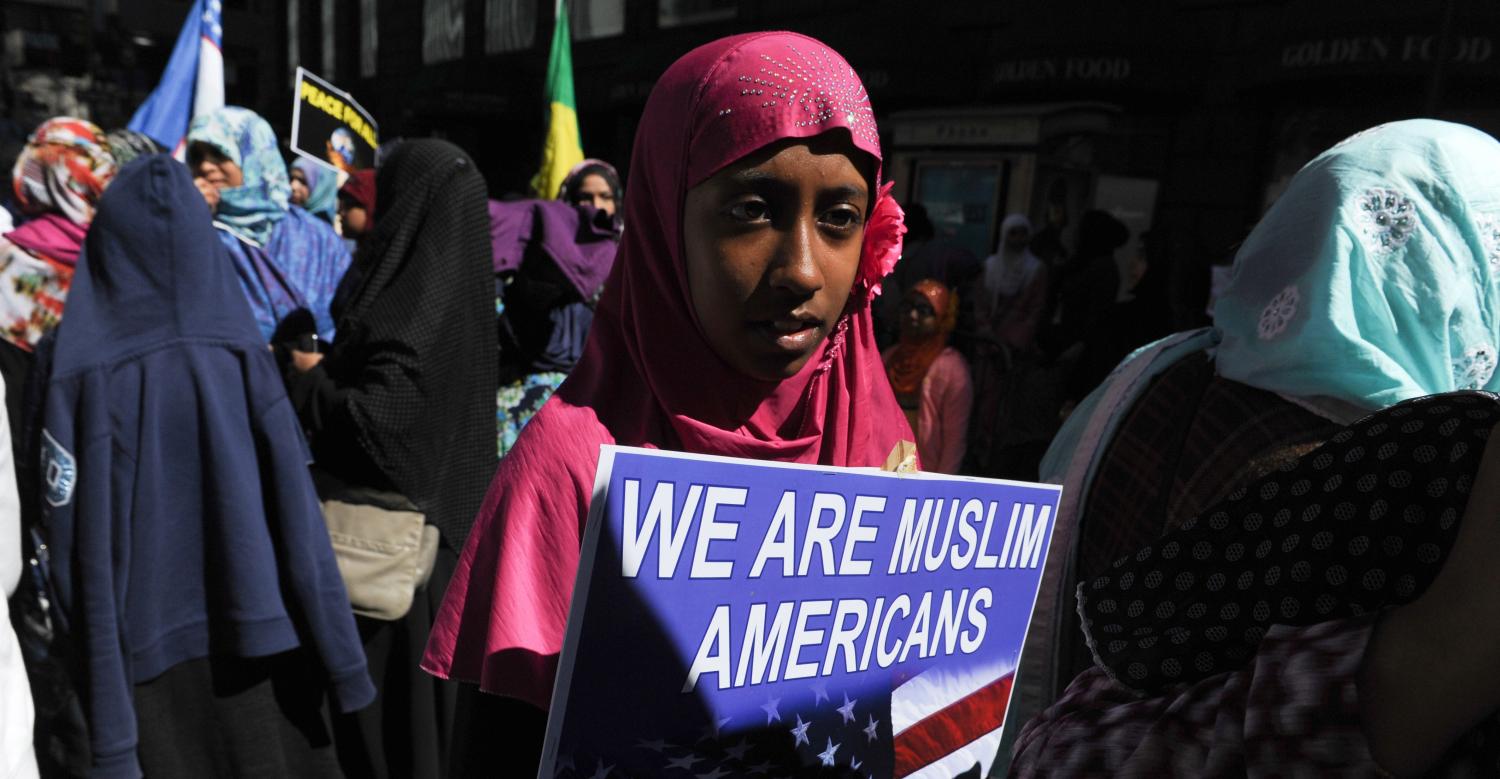 A girl wearing a Muslim headscarf holds a sign during the annual Muslim Day Parade in the Manhattan borough of New York City, September 25, 2016. REUTERS/Stephanie Keith - RTSPDPU