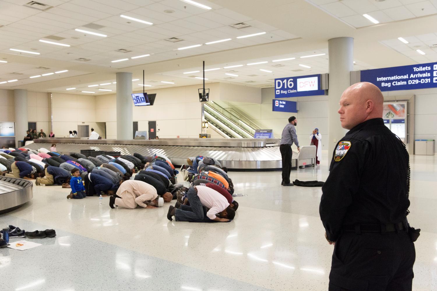 People gather to pray in baggage claim during a protest against the travel ban imposed by U.S. President Donald Trump's executive order, at Dallas/Fort Worth International Airport in Dallas, Texas, U.S. January 29, 2017. REUTERS/Laura Buckman TPX IMAGES OF THE DAY - RTSXXXO