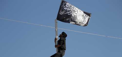 A member of al Qaeda's Nusra Front climbs a pole where a Nusra flag was raised at a central square in the northwestern city of Ariha, after a coalition of insurgent groups seized the area in Idlib province May 29, 2015. A Syrian insurgent alliance which has captured the last government-held town in the northwestern Idlib province made further advances on Friday, a monitoring group and fighters said. REUTERS/Khalil Ashawi - RTR4Y10S