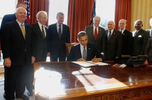 U.S. President Barack Obama (seated) signs into law H.R. 6156, the Russia and Moldova Jackson-Vanik Repeal and Magnitsky Rule of Law Accountability Act, in the Oval Office of the White House in Washington, December 14, 2012. From L-R are: U.S. Sen. Ben Cardin, U.S. Sen. Joe Lieberman, U.S. Sen. Max Baucus, Obama, U.S. Rep. Steny Hoyer, U.S. Rep. Sandy Levin, U.S. Rep. Jim McGovern, and U.S. Rep. Gregory Meeks. REUTERS/Larry Downing (UNITED STATES - Tags: POLITICS) - RTR3BKSF