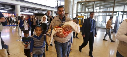 Syrian refugee Ahmad al Aboud, and his family members, who will be resettled in the United States as part of a refugee admissions programme, walk to board their plane at the Queen Alia International Airport in Amman, Jordan, April 6,2016. REUTERS/Muhammad Hamed. - RTSDU4K