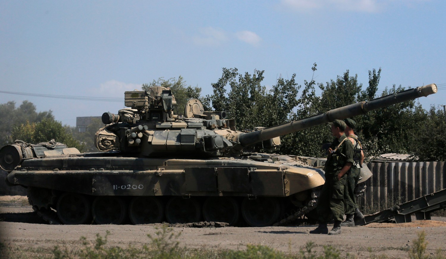 Russian soldiers are pictured next to a tank in Kamensk-Shakhtinsky, Rostov region, near the border with Ukraine, August 23, 2014. NATO Secretary General Anders Fogh Rasmussen said on Friday the alliance had observed an alarming build-up of Russian ground and air forces in the vicinity of Ukraine. REUTERS/Alexander Demianchuk (RUSSIA - Tags: MILITARY POLITICS CIVIL UNREST CONFLICT) - RTR43GHH