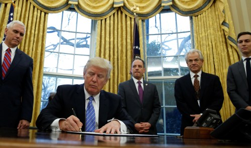 U.S. President Donald Trump, watched by (L-R) Vice President Mike Pence, White House Chief of Staff Reince Priebus, head of the White House Trade Council Peter Navarro and senior advisor Jared Kushner, signs an executive order