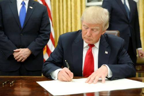 U.S. President Donald Trump signs his first executive orders in the Oval Office in Washington, U.S. January 20, 2017. REUTERS/Jonathan Ernst - RTSWLUX