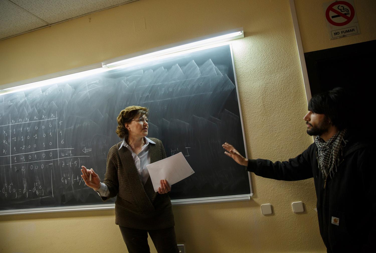 A professor tries to stop striking students from disrupting her class at Complutense University on the second day of a 48-hour student strike to protest against rising fees and educational cuts in Madrid March 27, 2014.