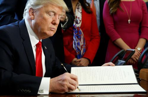 U.S. President Donald Trump signs an executive order rolling back regulations from the 2010 Dodd-Frank law on Wall Street.