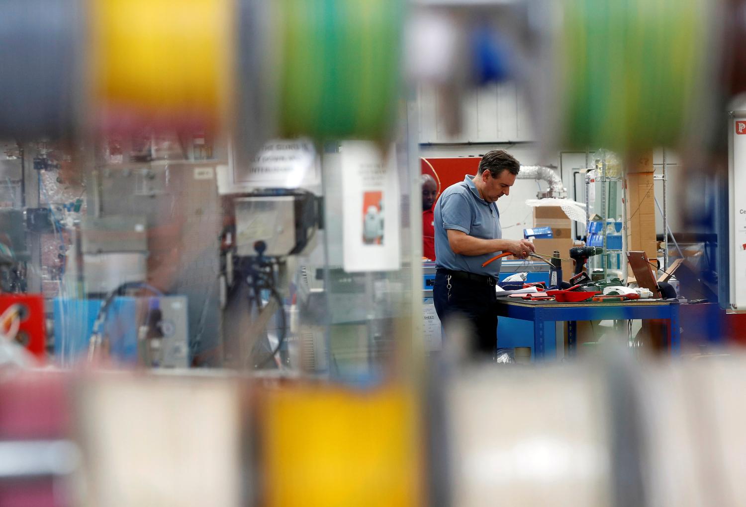 A man works on an electrical component on the factory floor of PP Control and Automation near Cannock, Britain