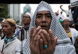 REUTERS/Beawiharta - Members of the Islamic Defenders Front (FPI) pray during a protest in front of the Indonesian police headquarters in Jakarta, Indonesia, January 23, 2017.