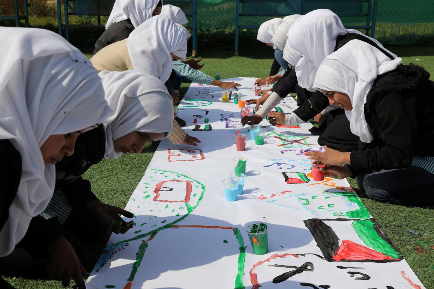 Bedouin Palestinian schoolgirls paint at their school in al-Khan al-Ahmar village near the West Bank city of Jericho February 23, 2017. REUTERS/ Ammar Awad - RTSZZG6