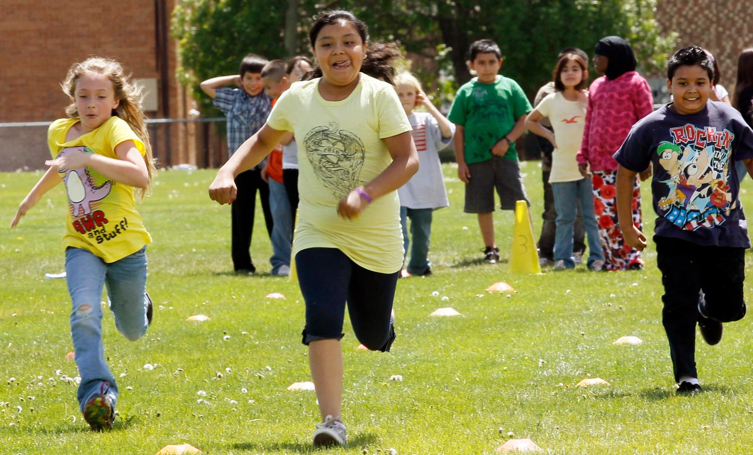 Students at Rose Hill Elementary School (L-R) Alexis Reubenstein, Delmy Roman-Sanchez and Jesus Anguiano participate in a running race during physical education class in Commerce City, Colorado May 1, 2012.