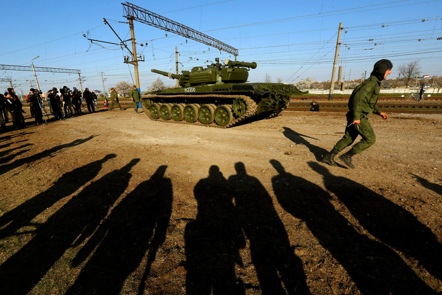 A Russian tank crew member runs in front of his T-72B tank after their arrival in Crimea in the settlement of Gvardeiskoye near the Crimean city of Simferopol March 31, 2014. Russia is withdrawing a motorized infantry battalion from a region near Ukraine's eastern border, the Russian Defence Ministry was quoted as saying by state news agencies on Monday. REUTERS/Yannis Behrakis (UKRAINE - Tags: POLITICS CONFLICT TPX IMAGES OF THE DAY) - RTR3JCY3