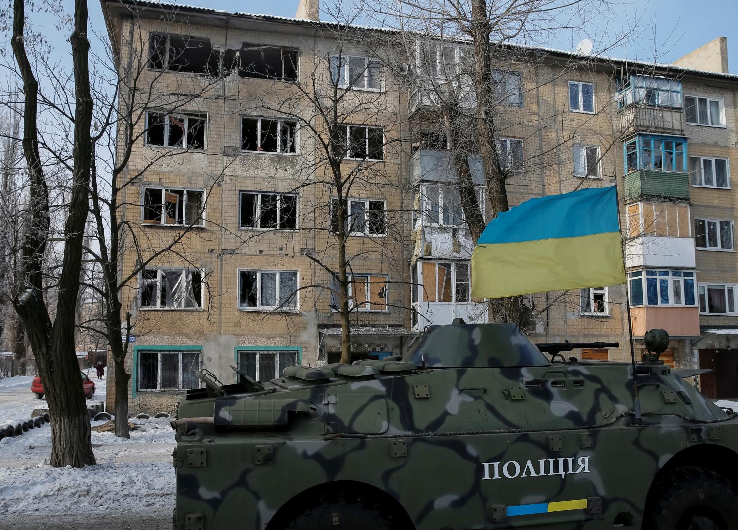 An armoured personnel carrier (APC) patrols near the building which was damaged during fighting between the Ukrainian army and pro-Russian separatists, in the government-held industrial town of Avdiyivka, Ukraine, February 3, 2017. REUTERS/Gleb Garanich - RTX2ZI06