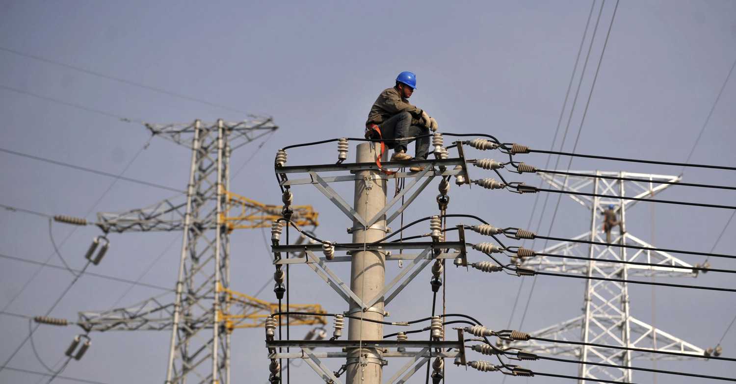 A labourer rests on top of a power pole in Hankou, Hubei province November 4, 2009. China is pushing to complete its first commercial-scale power plant that can capture and store emissions, but must do more research on how and where to lock away carbon dioxide if the technology is to get wide roll-out. To match ANALYSIS story CHINA-CARBON/CAPTURE REUTERS/China Daily (CHINA BUSINESS SCI TECH) CHINA OUT. NO COMMERCIAL OR EDITORIAL SALES IN CHINA - RTXQBY5