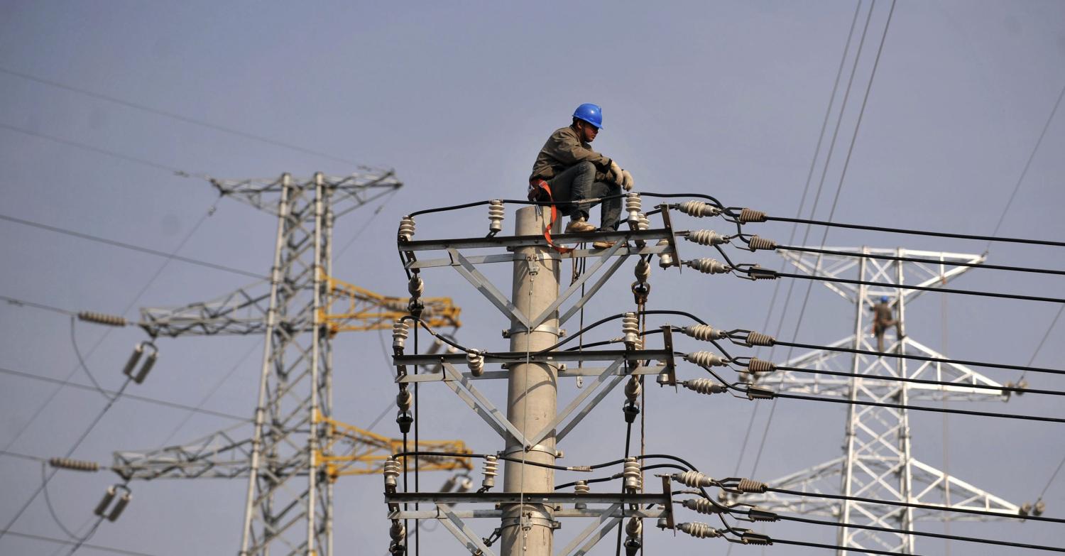 A labourer rests on top of a power pole in Hankou, Hubei province November 4, 2009. China is pushing to complete its first commercial-scale power plant that can capture and store emissions, but must do more research on how and where to lock away carbon dioxide if the technology is to get wide roll-out. To match ANALYSIS story CHINA-CARBON/CAPTURE REUTERS/China Daily (CHINA BUSINESS SCI TECH) CHINA OUT. NO COMMERCIAL OR EDITORIAL SALES IN CHINA - RTXQBY5