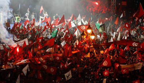 Supporters of the Islamist Ennahda movement wave flags during a rally at Kasbah Square in Tunis August 3, 2013. Tens of thousands of Tunisians came out in a show of force for the country's Islamist-led government on Saturday, in one of the largest demonstrations since the 2011 revolution. REUTERS/Zoubeir Souissi (TUNISIA - Tags: POLITICS CIVIL UNREST) - RTX129S6