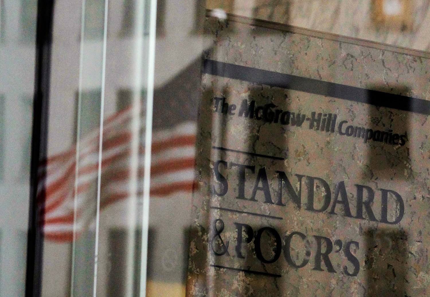 A U.S. flag is reflected in a window of the Standard and Poor's building.