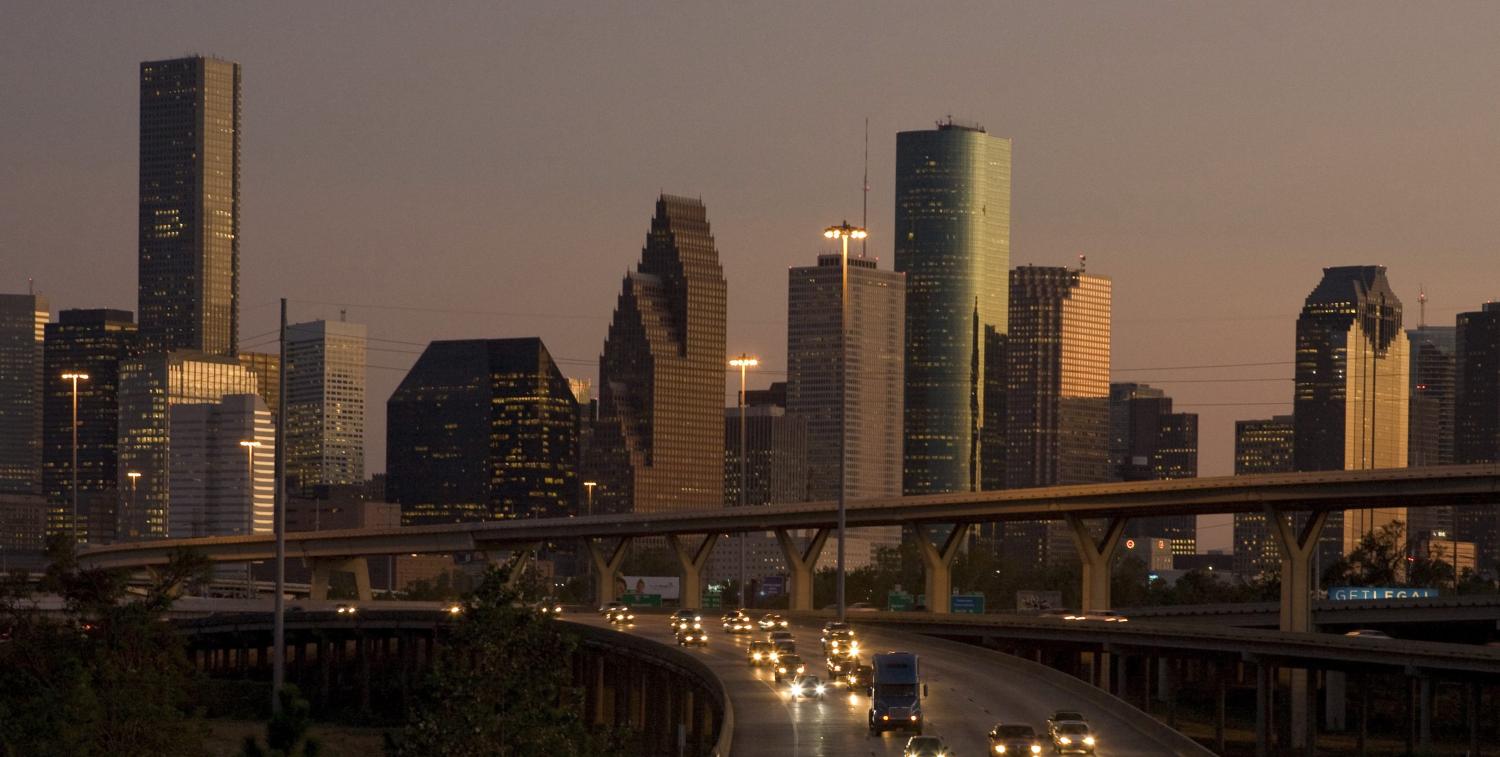 Traffic flows at dusk with the downtown Houston skyline in the background as night falls on America's fastest growing large city October 3, 2008. Even after Hurricane Ike smashed thousands of windows in Houston's skyscrapers last month, times could not be much better in the Petro Metro. While the ill wind of economic turmoil sweeps across America, Houston has been shielded by a combination of low housing prices, a sagging U.S. dollar and surging profits for energy companies based here. Picture taken October 3. To match feature USA-HOUSTON REUTERS/Richard Carson (UNITED STATES) - RTX9IQ8