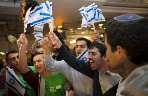 Supporters of the far right Bayit Yehudi party headed by Naftali Bennett celebrate at the party's headquarters in Ramat Gan, near Tel Aviv January 22, 2013. Hawkish Prime Minister Benjamin Netanyahu emerged the bruised winner of Israel's election on Tuesday, claiming victory despite unexpected losses to resurgent centre-left challengers. Netanyahu has traditionally looked to religious, conservative parties for backing and is widely expected to seek out self-made millionaire Bennett, who heads the Jewish Home party and stole much of the limelight during the campaign. REUTERS/Ronen Zvulun