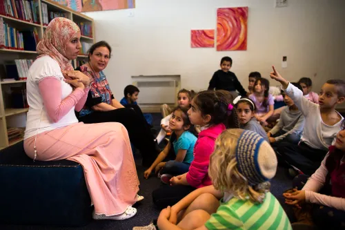 Alia Tunisi (L) and Sharon Suval (2nd L), first grade school teachers, talk to their students during reading hour at the Hand in Hand Arab Jewish bilingual school in Jerusalem December 3, 2014. The Hand in Hand school in Jerusalem presents an almost too-perfect scene in a tense and divided city, where Jews and Arabs do daily business but rarely befriend one other. REUTERS/Ronen Zvulun