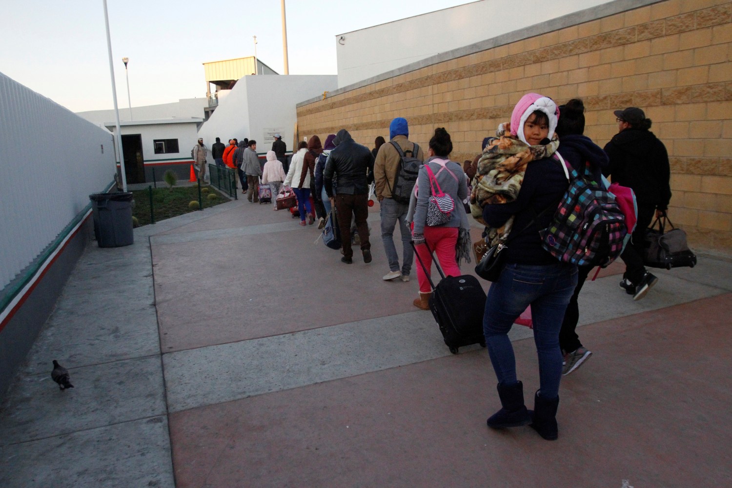 Immigrants from Central America and Mexican citizens queue to cross into the U.S. to apply for asylum at the new border crossing of El Chaparral in Tijuana