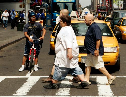 A cyclist smiles as he watches pedestrians walk across a street near Times Square in New York