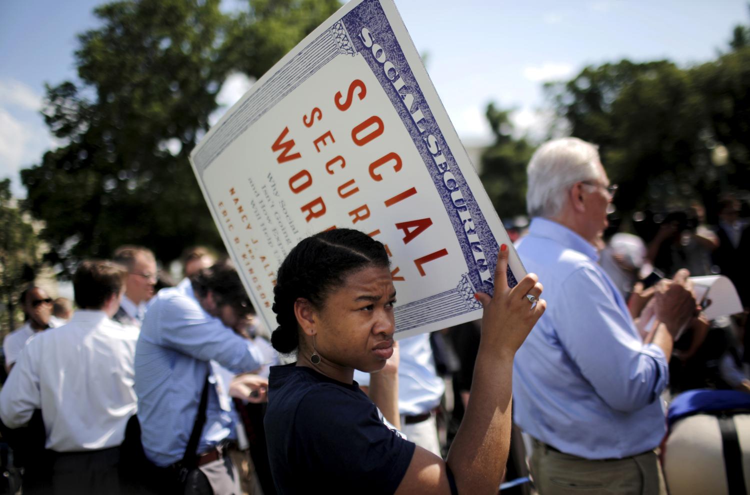 A woman holds a sign as she attends an event in support of New York City Mayor Bill de Blasio's progressive agenda against income inequality outside the U.S. Capitol in Washington