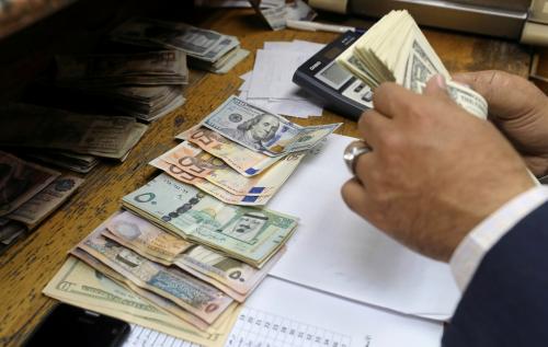 A man counts U.S dollar and Euro banknotes at a money exchange office in central Cairo