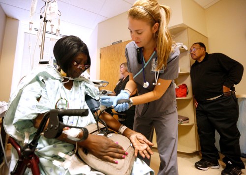 Registered nurse Paige Duracher checks Jacqueline Parker's vitals in the cardiac step-down area of the University of Mississippi Medical Center in Jackson, Mississippi