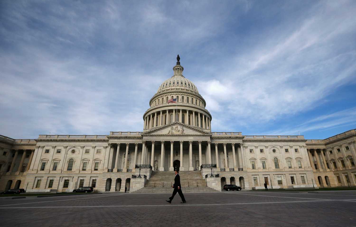 A lone worker passes by the U.S. Capitol building in Washington