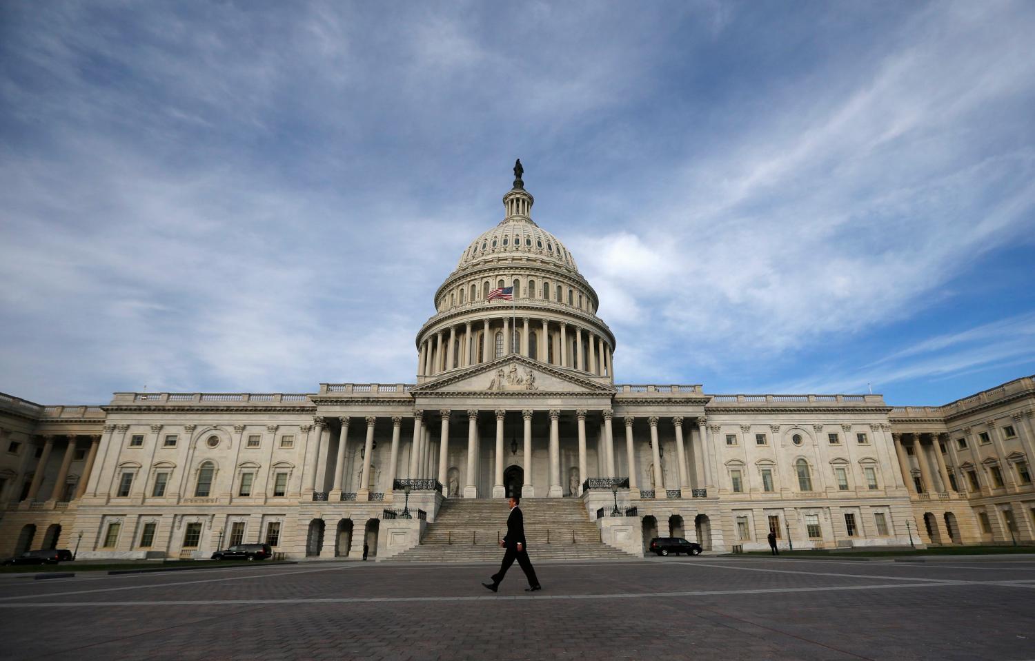 A lone worker passes by the U.S. Capitol building in Washington