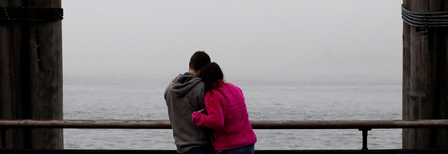 A couple pose for a selfie during a foggy morning commute in New York's Harbor.
