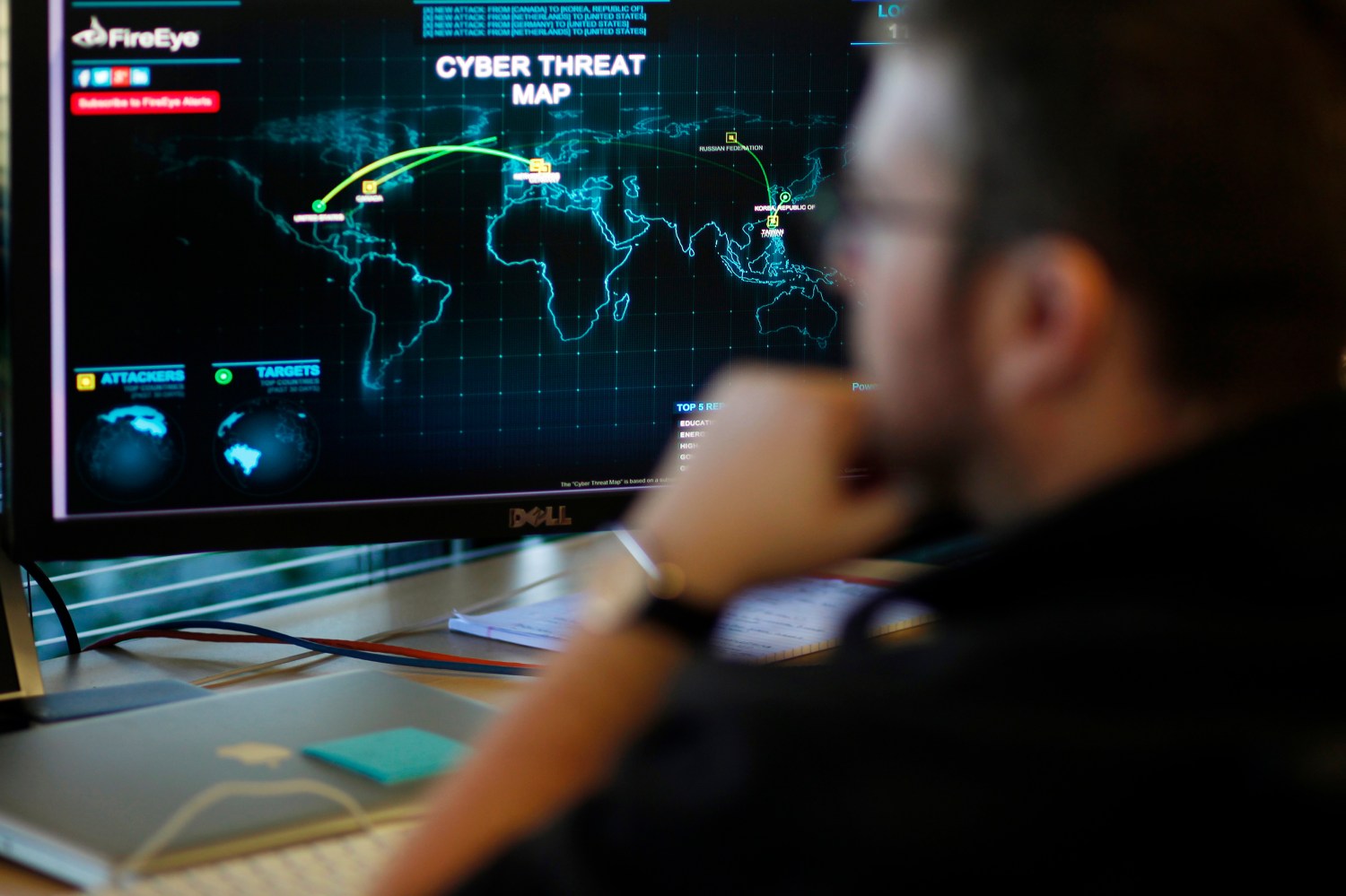 A FireEye information analyst works in front of a screen showing a near real-time map tracking cyber threats at the FireEye office in Milpitas, California, December 29, 2014. FireEye is the security firm hired by Sony to investigate last month's cyberattack against Sony Pictures. Picture taken December 29. REUTERS/Beck Diefenbach (UNITED STATES - Tags: BUSINESS SCIENCE TECHNOLOGY CRIME LAW) - RTR4JTQC