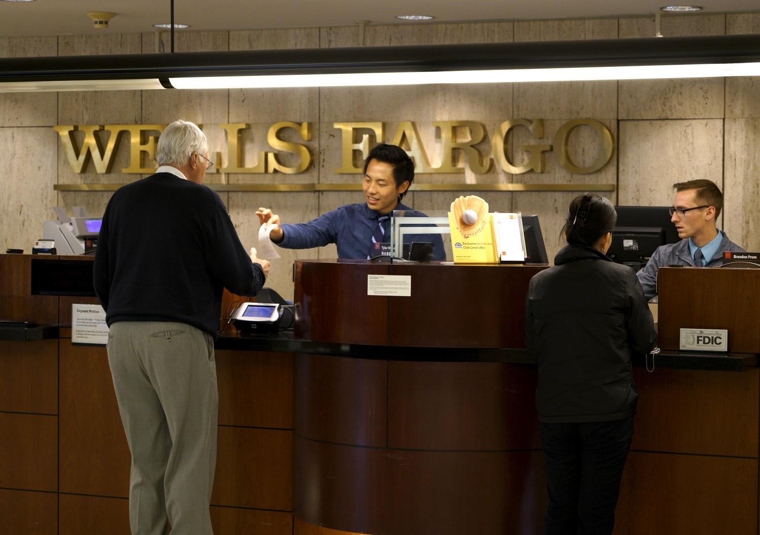 Tellers serve customers at the Wells Fargo & Co. bank.