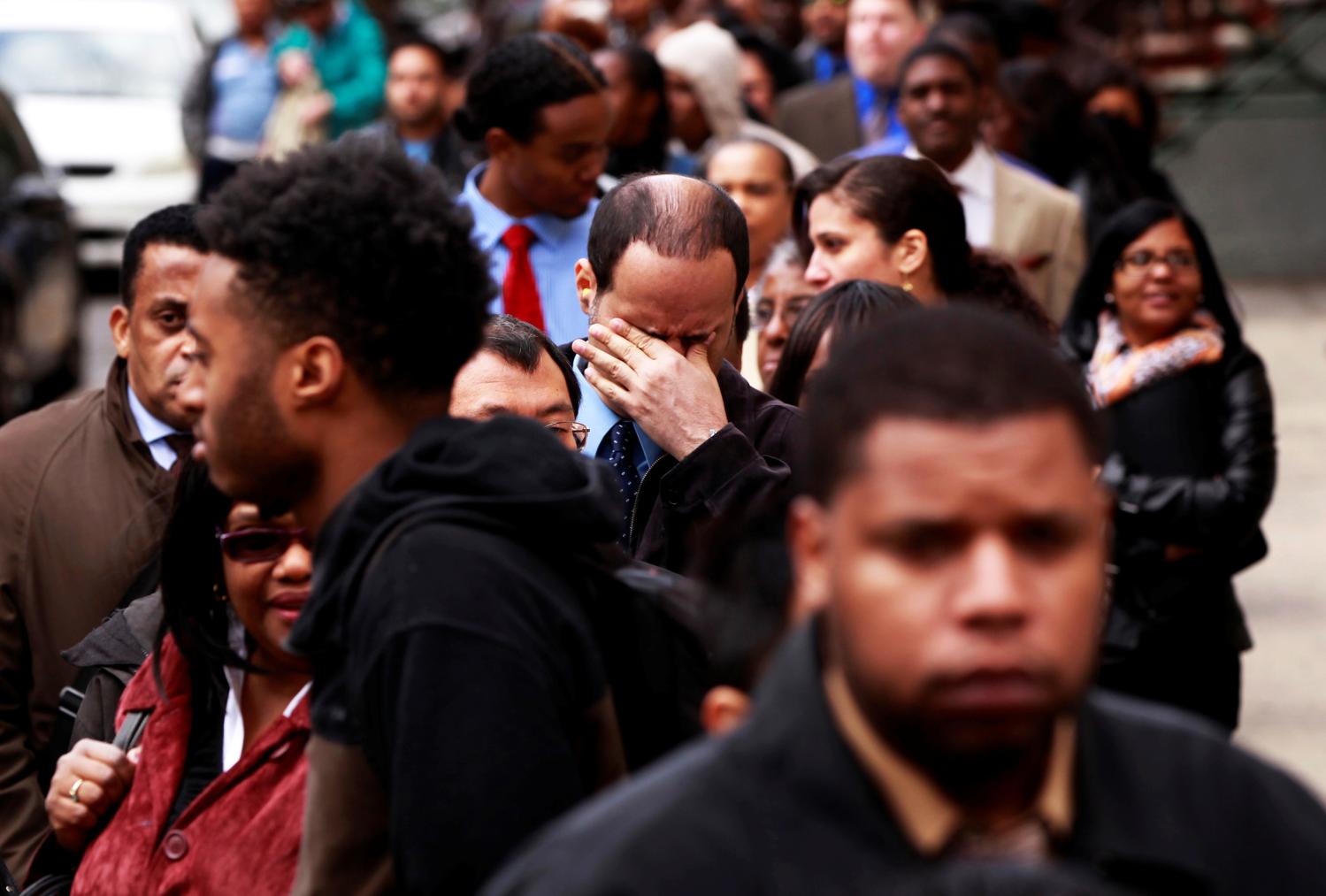 FILE PHOTO -- A man rubs his eyes as he waits in a line of jobseekers, to attend the Dr. Martin Luther King Jr. career fair held by the New York State department of Labor in New York April 12, 2012. REUTERS/Lucas Jackson/File Photo - RTX2NWJ6
